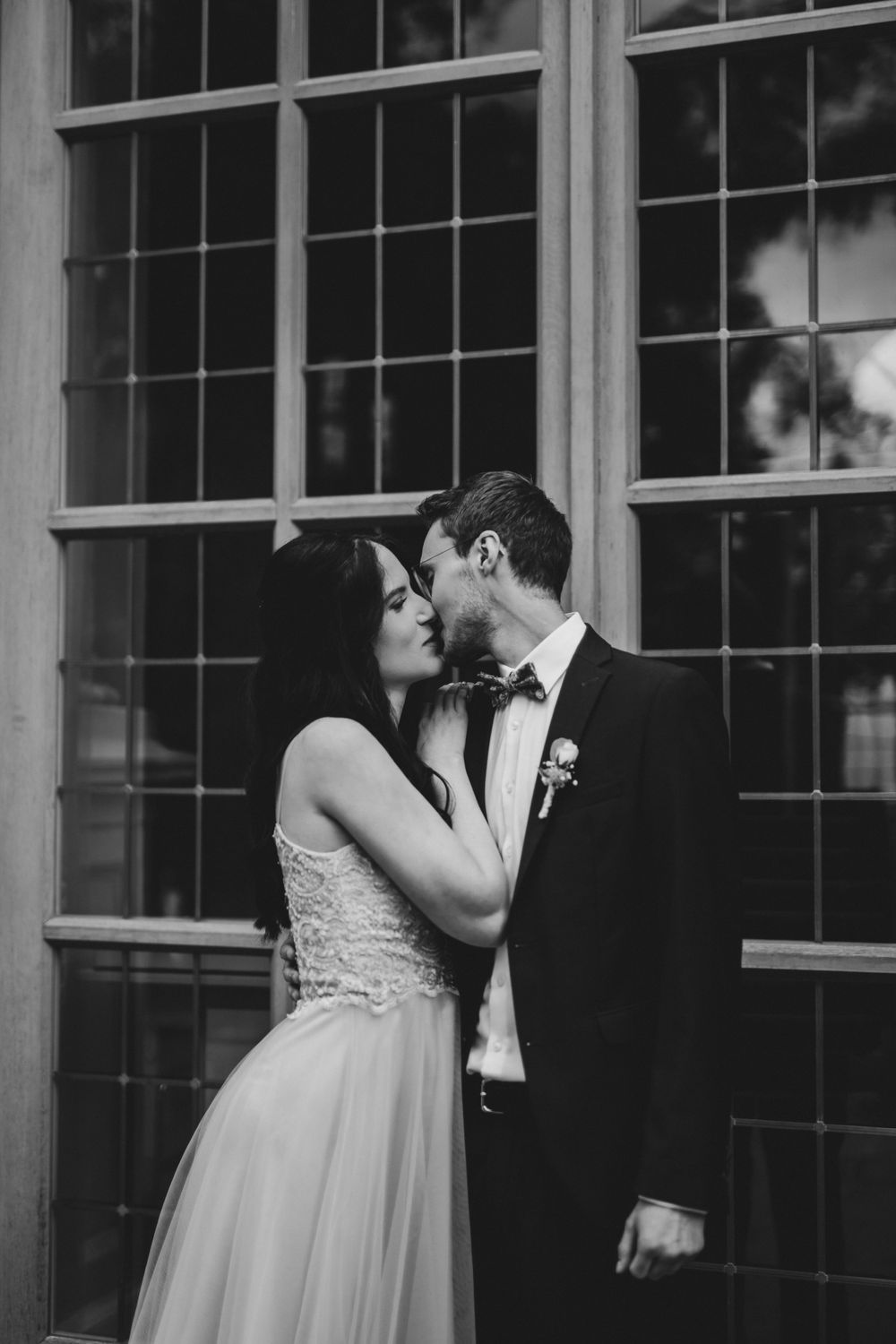A series of intimate moments captured against a window-lined building facade.