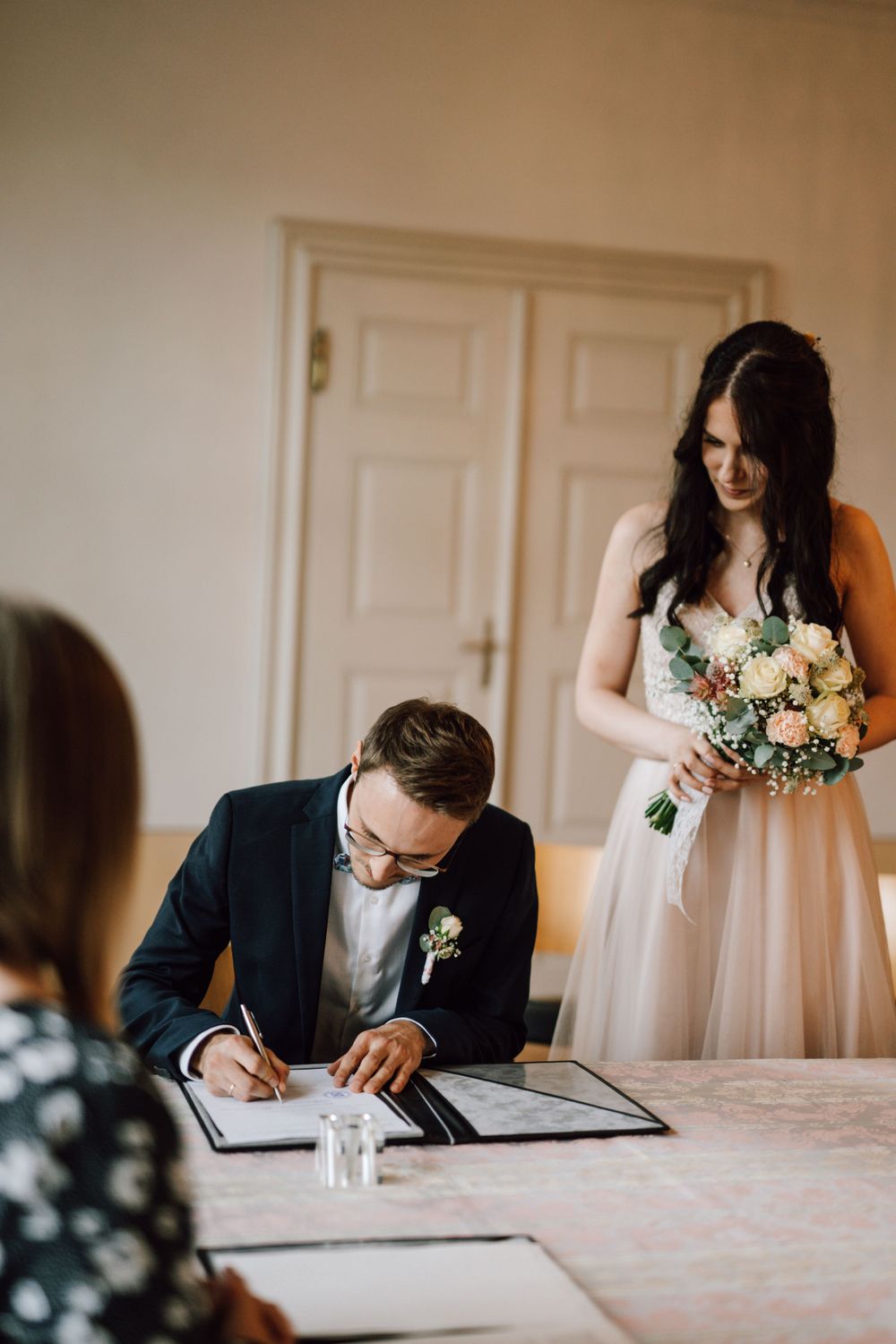A couple signs their marriage license during their wedding ceremony.