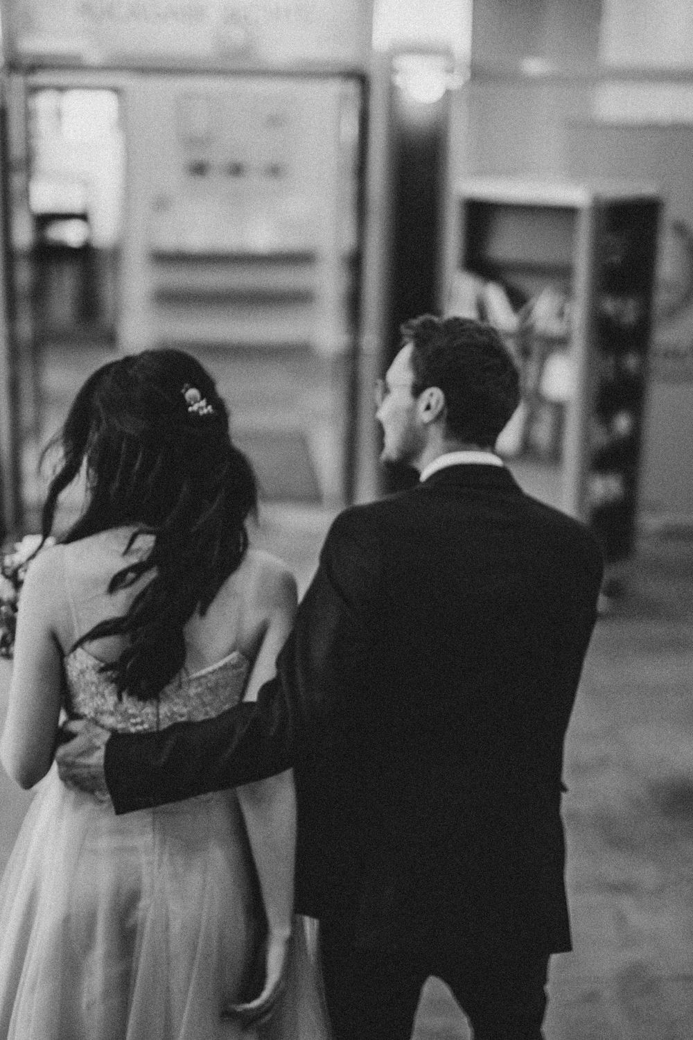 A couple walks together in formal wedding attire.