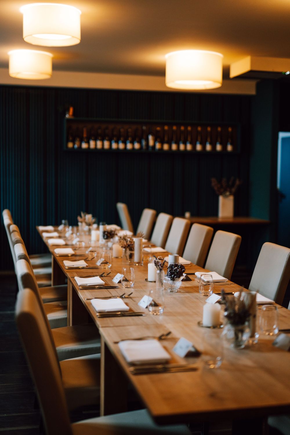 Elegant restaurant dining table setup with white chairs and warm lighting in an upscale venue.