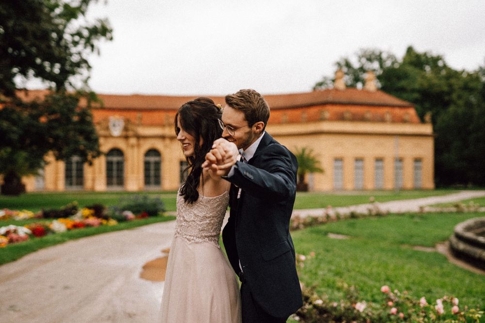 Newlyweds share intimate moments on the grounds of a beautiful terracotta building.