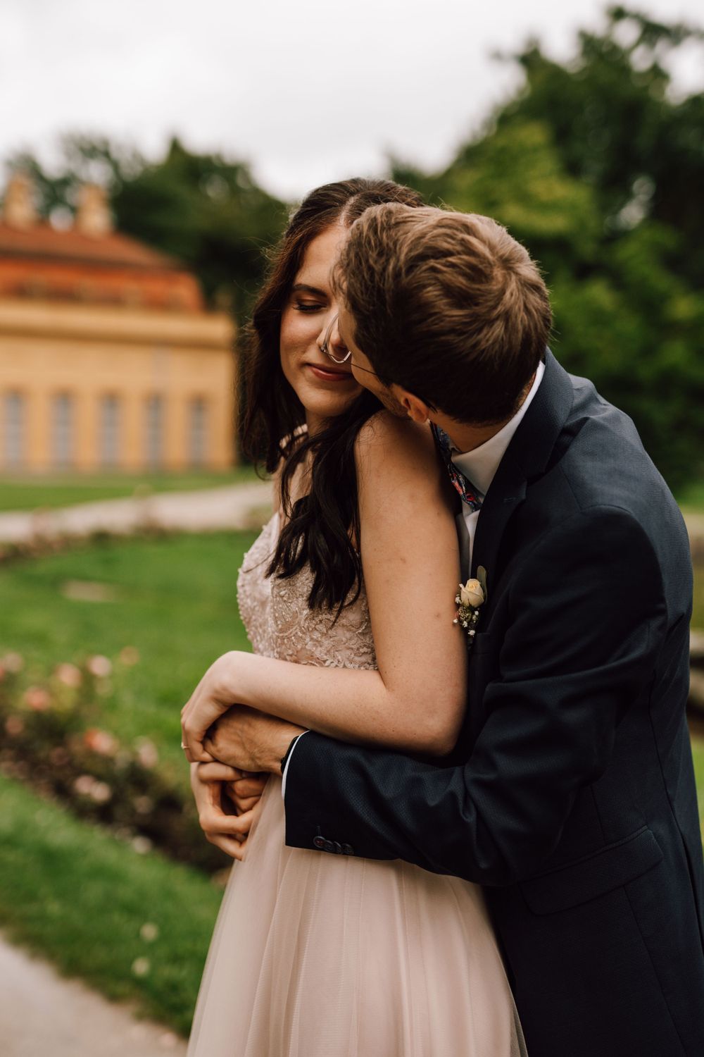 Romantic wedding portraits captured in front of a historic orange building.