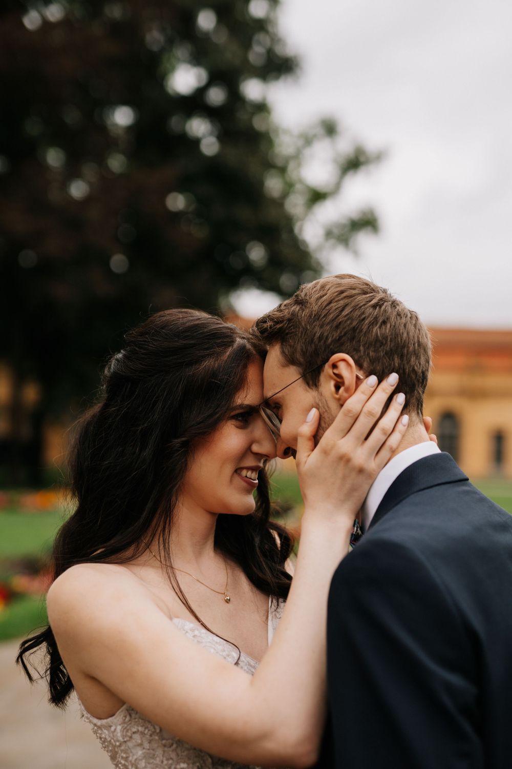 An emotional moment between a couple against a natural outdoor backdrop.
