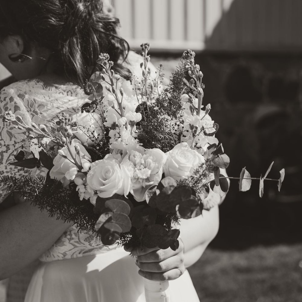 Black and white photo of elegant wedding bouquet with roses and mixed flowers.