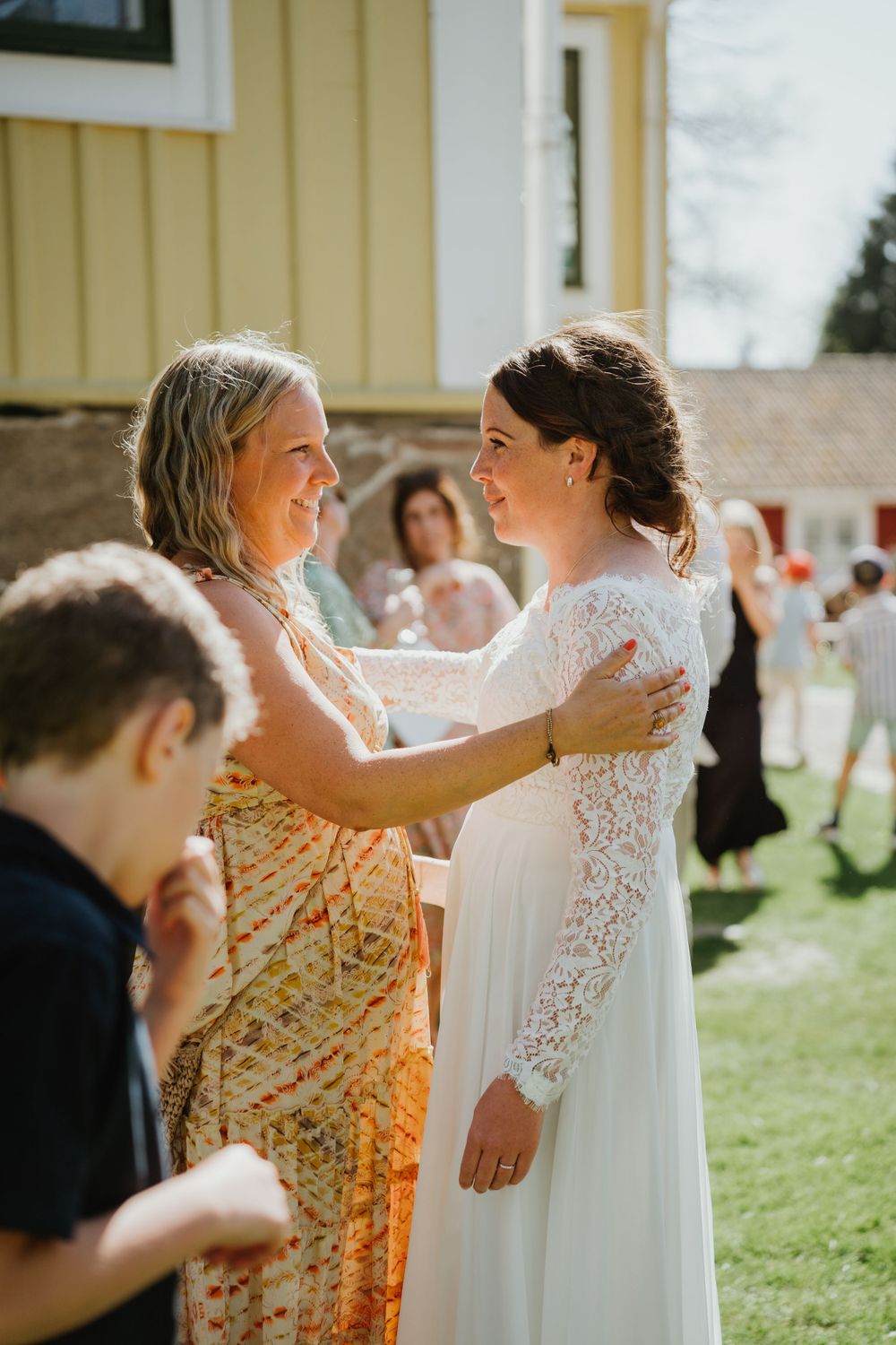 Emotional moment shared during outdoor wedding reception on a sunny afternoon.
