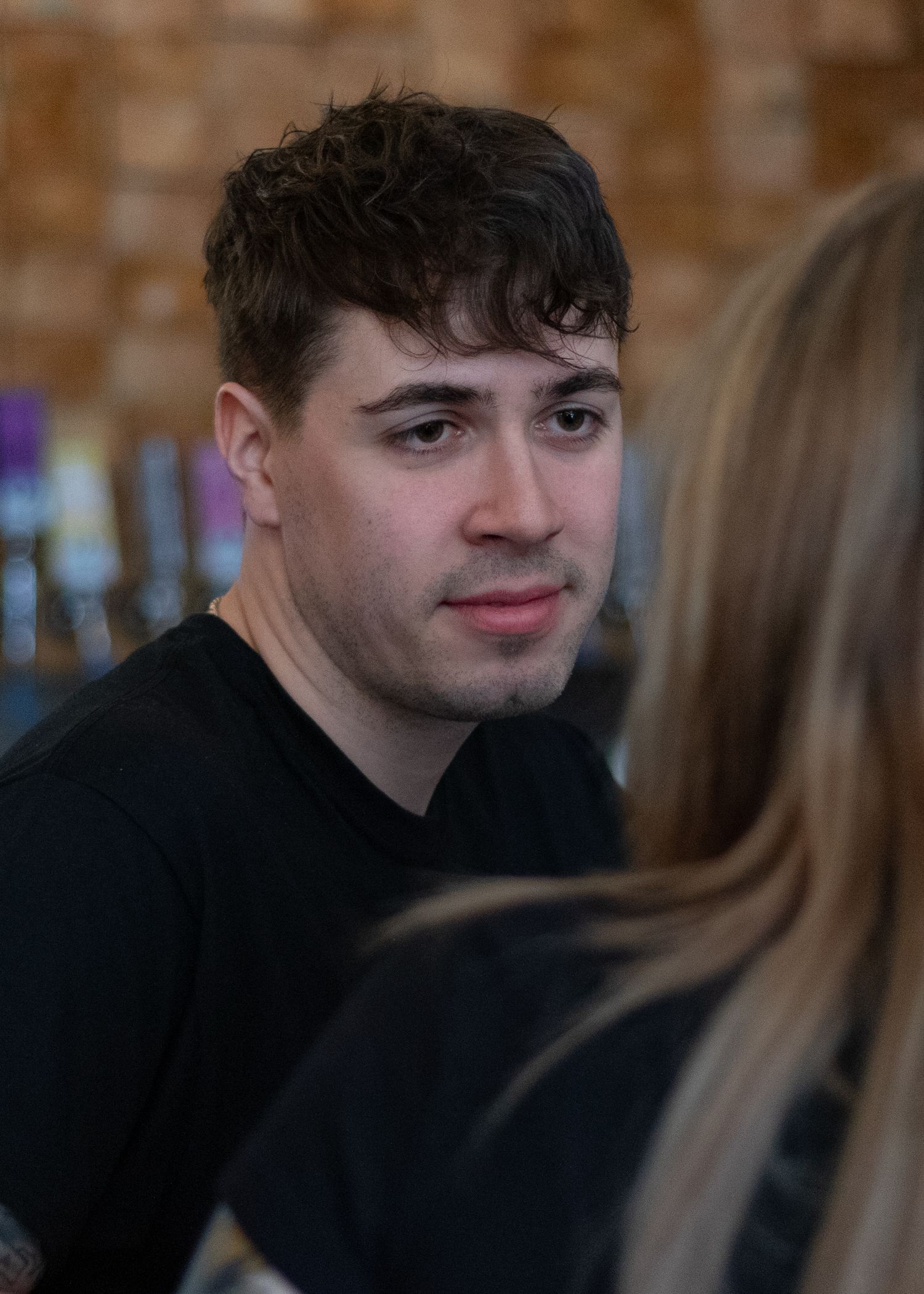 An intimate indoor scene against a brick wall background.