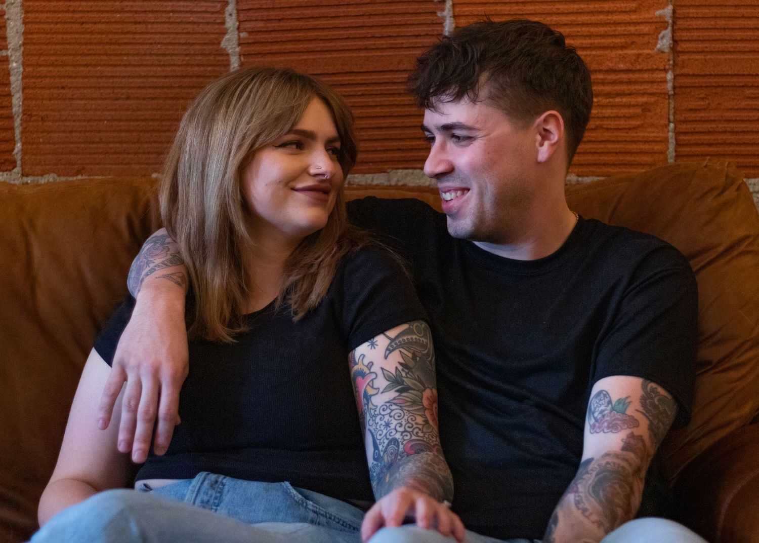 Two people sharing a close moment on a couch.