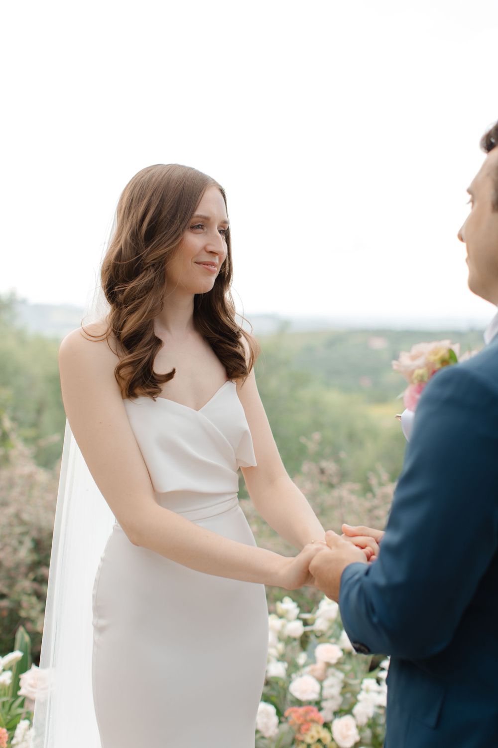 A close-up portrait of Suzanne, her expression reflecting a mix of excitement and tender emotion on her wedding day