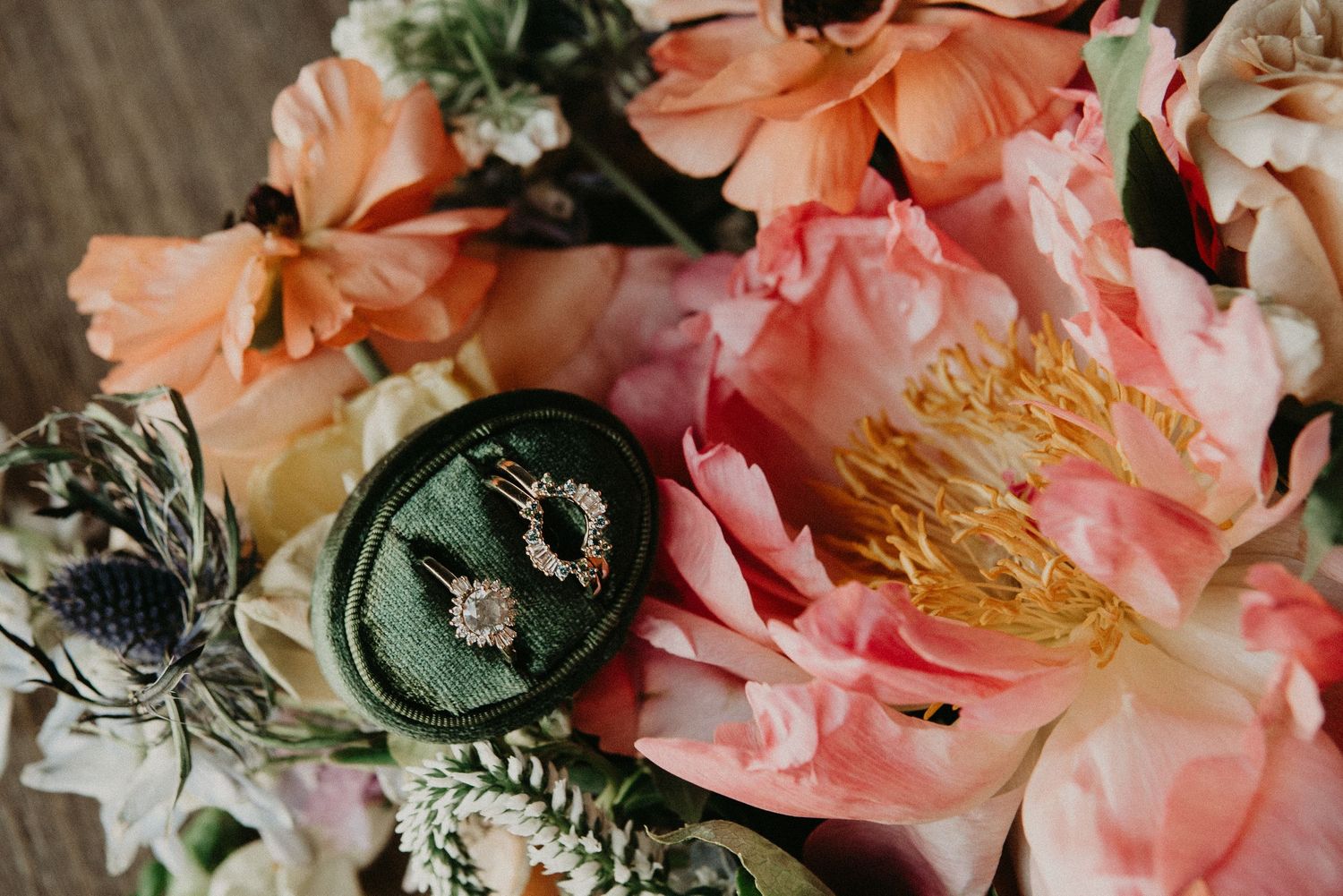 Close-up of pink and peach wedding florals with ornate ring box.