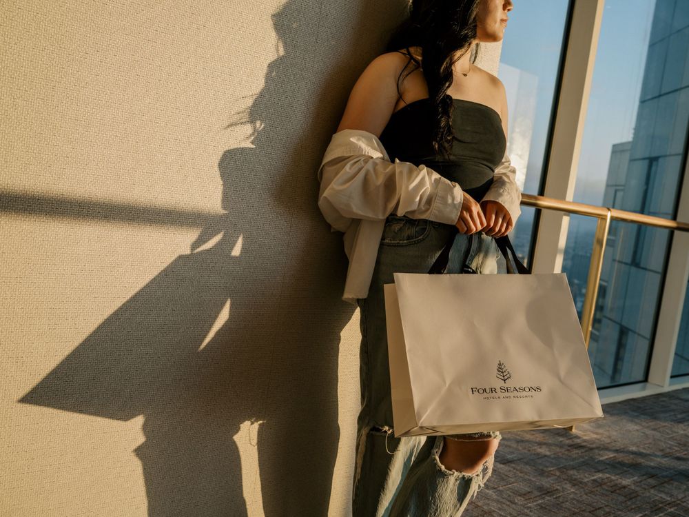 Shopping scene with dramatic shadows and a luxury shopping bag in soft natural light.