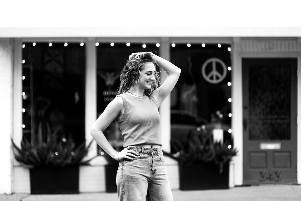 Senior graduate black and white street style portrait in front of storefront