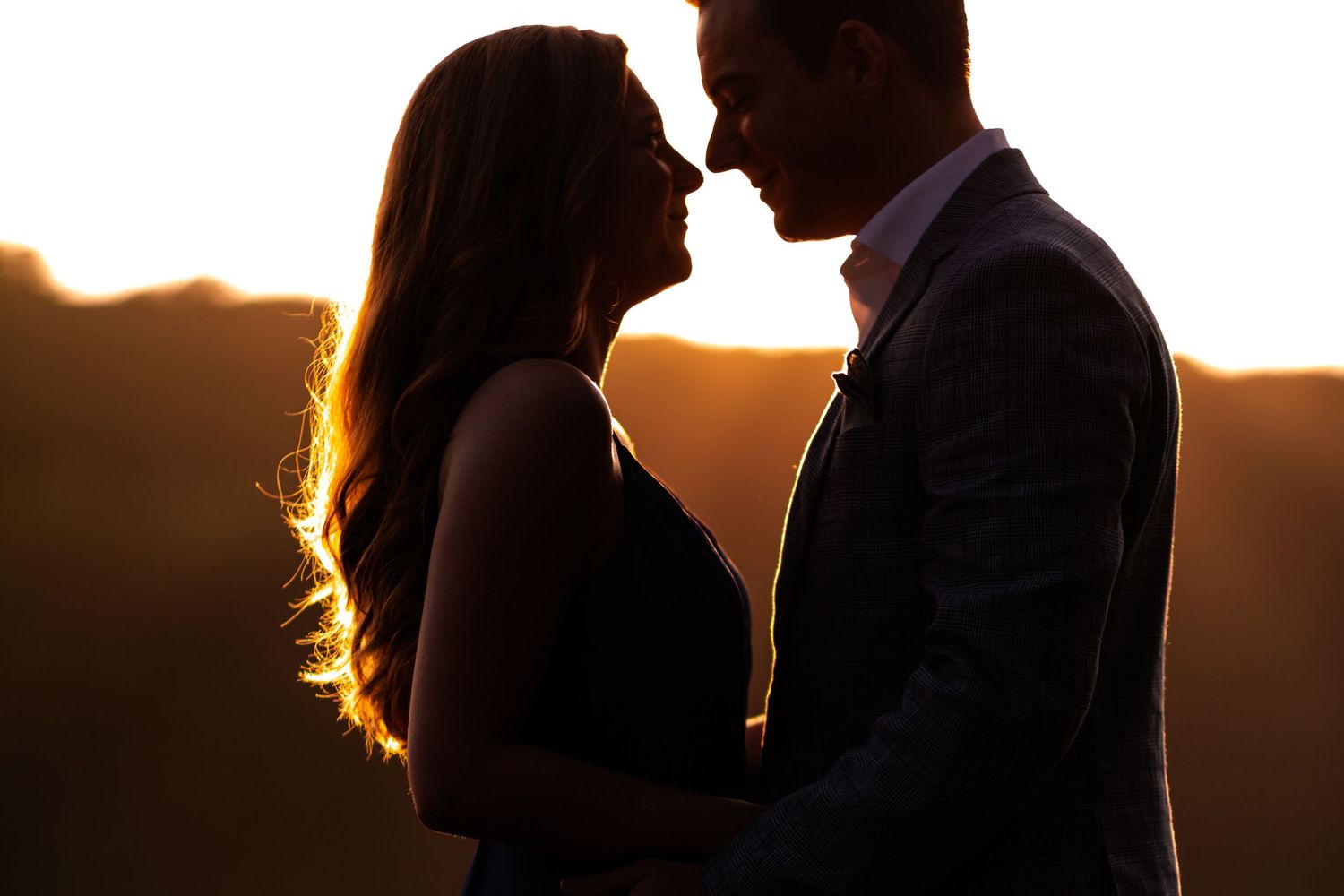 Romantic silhouettes of a couple against a golden sunset sky.
