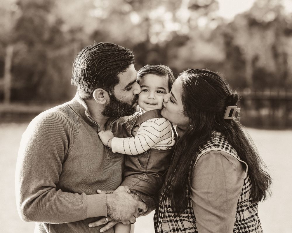 A series of black and white photos showing tender family moments between parents and children outdoors.