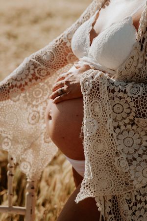 Delicate white lace detail of a dress photographed in warm sunlight.