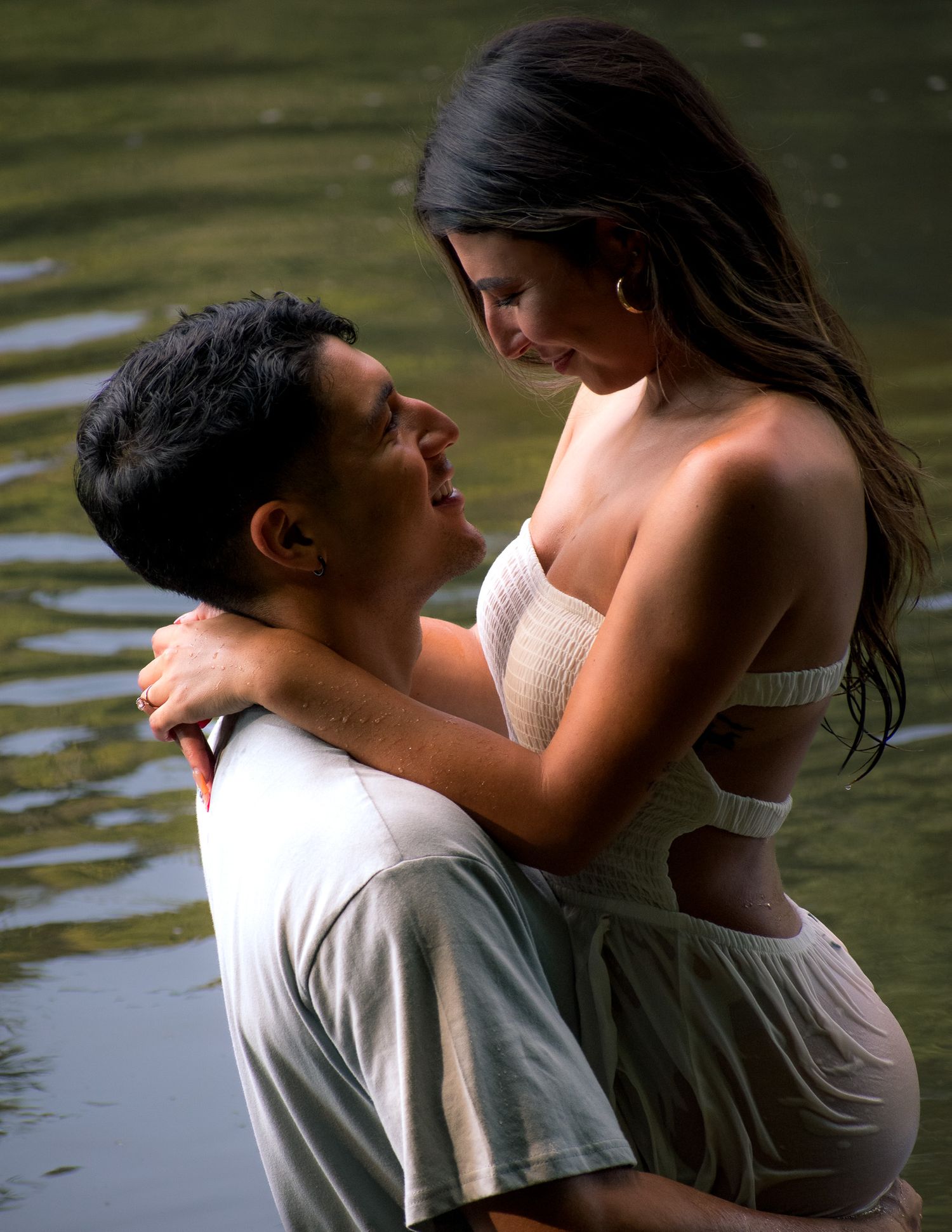 Intimate couple poses together in water during nature photography session.
