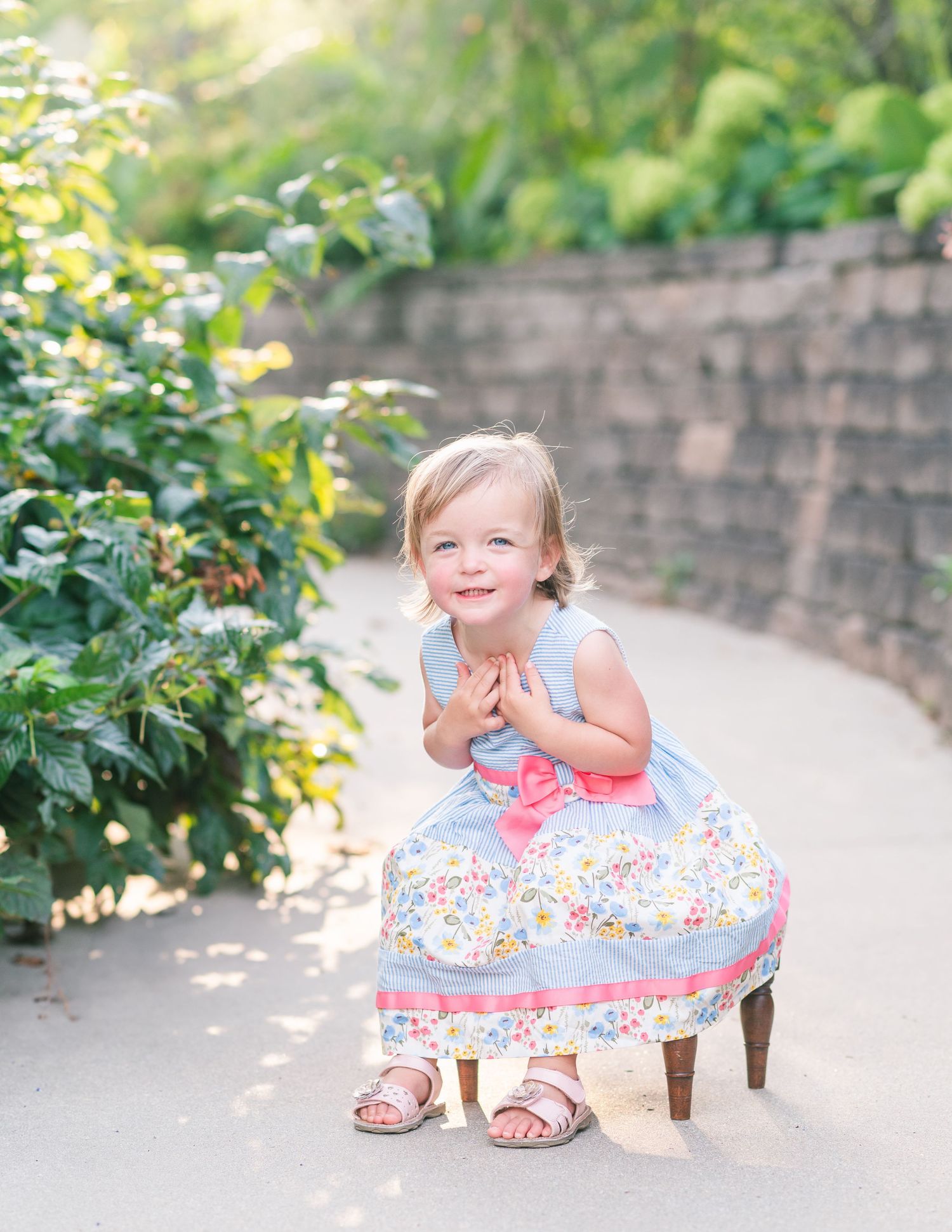 Shelbyville, Illinois little girl in a blue and pink dress laughing during a family session in the Botanical Garden by Julie Loy Photography