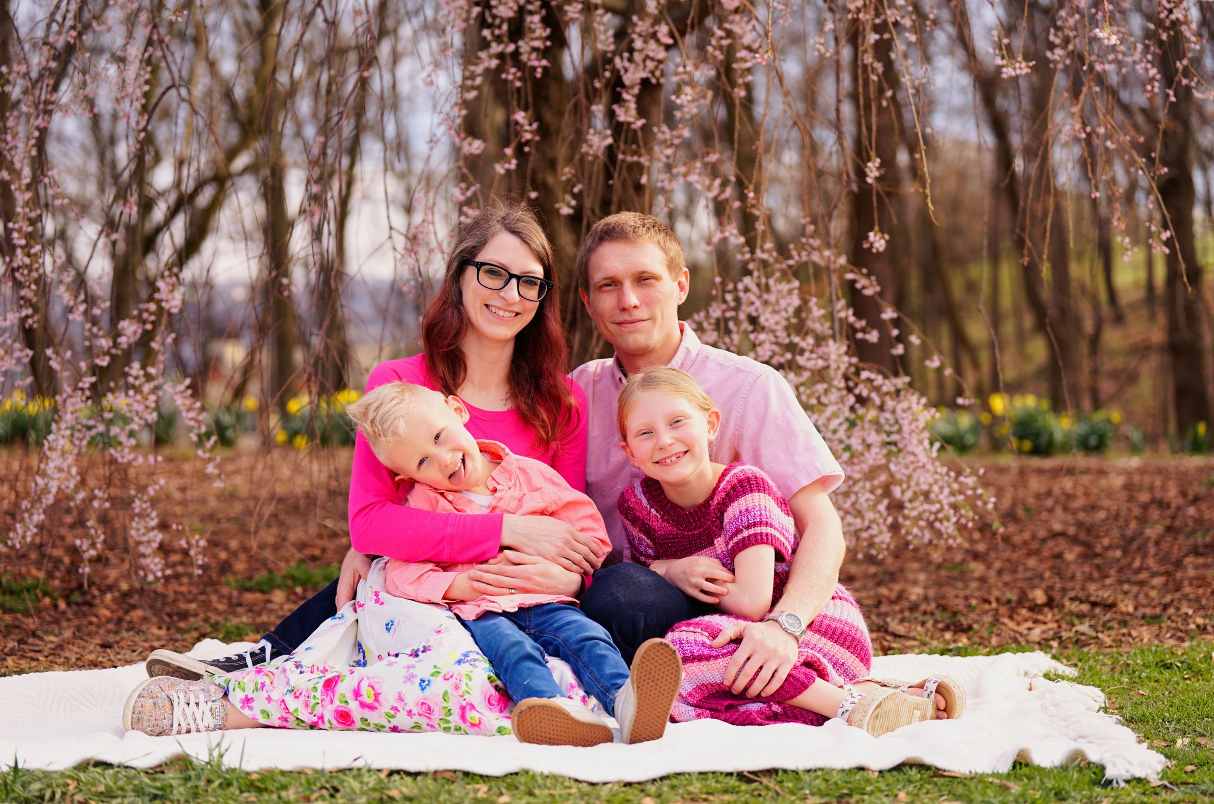 Chelsea and Cody getting family portraits with their kids at Ault Park in Cincinnati Ohio with the cherry blossoms