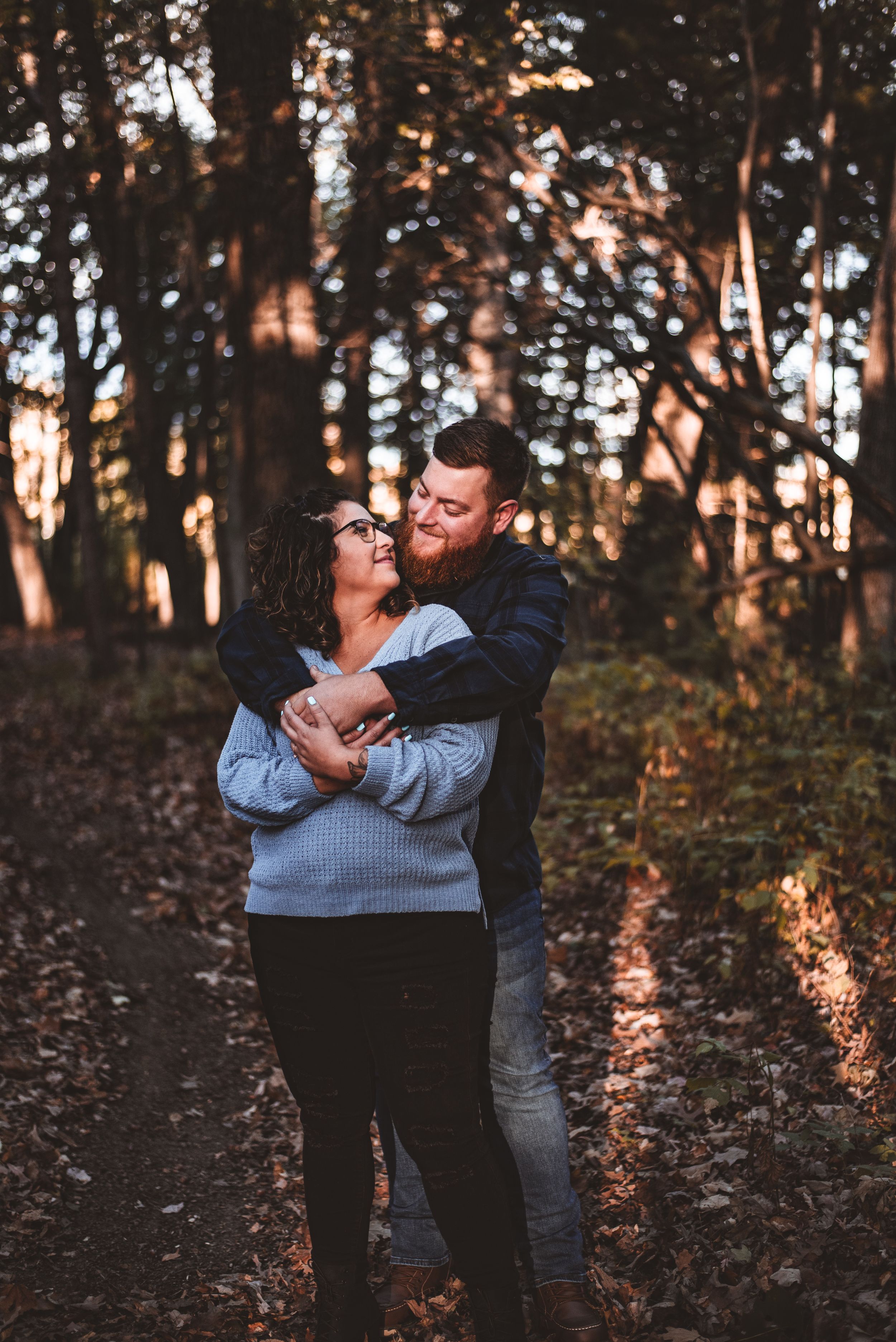 A romantic autumn forest photoshoot featuring an intimate embrace at sunset.