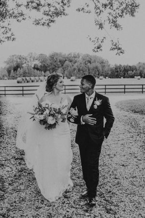 A black and white wedding photo series showing a bride and groom sharing playful moments in a scenic outdoor setting.