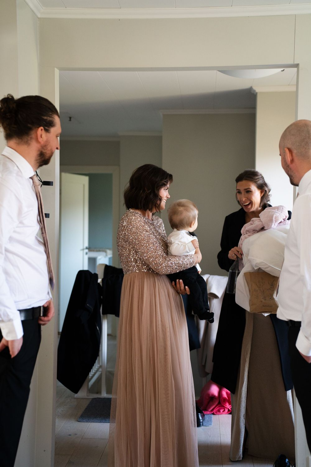 Wedding party getting ready in home interior with formal attire.