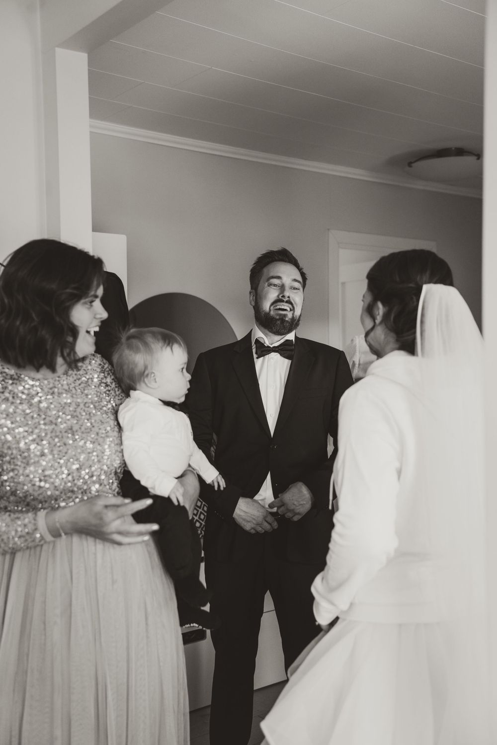 An emotional moment during a wedding ceremony with family gathered indoors in formal attire.