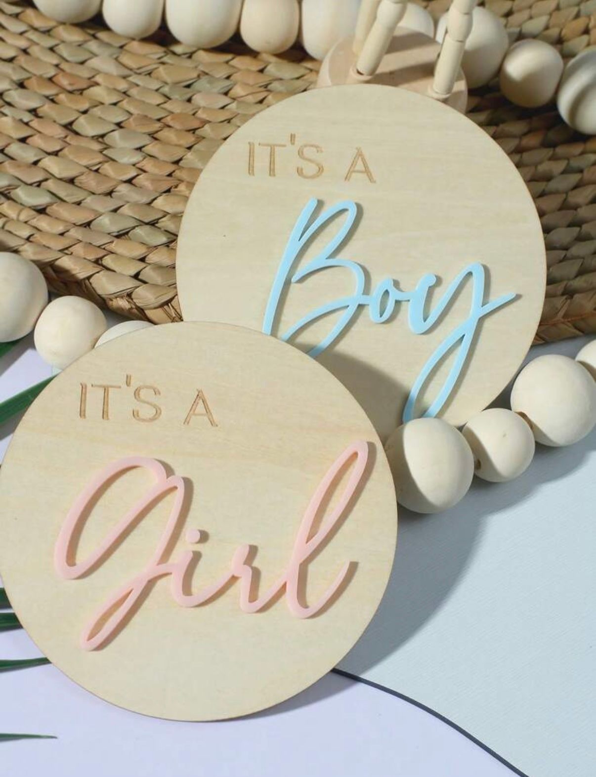 Wooden gender reveal signs with 'It's a Girl' text in pink and blue lettering.