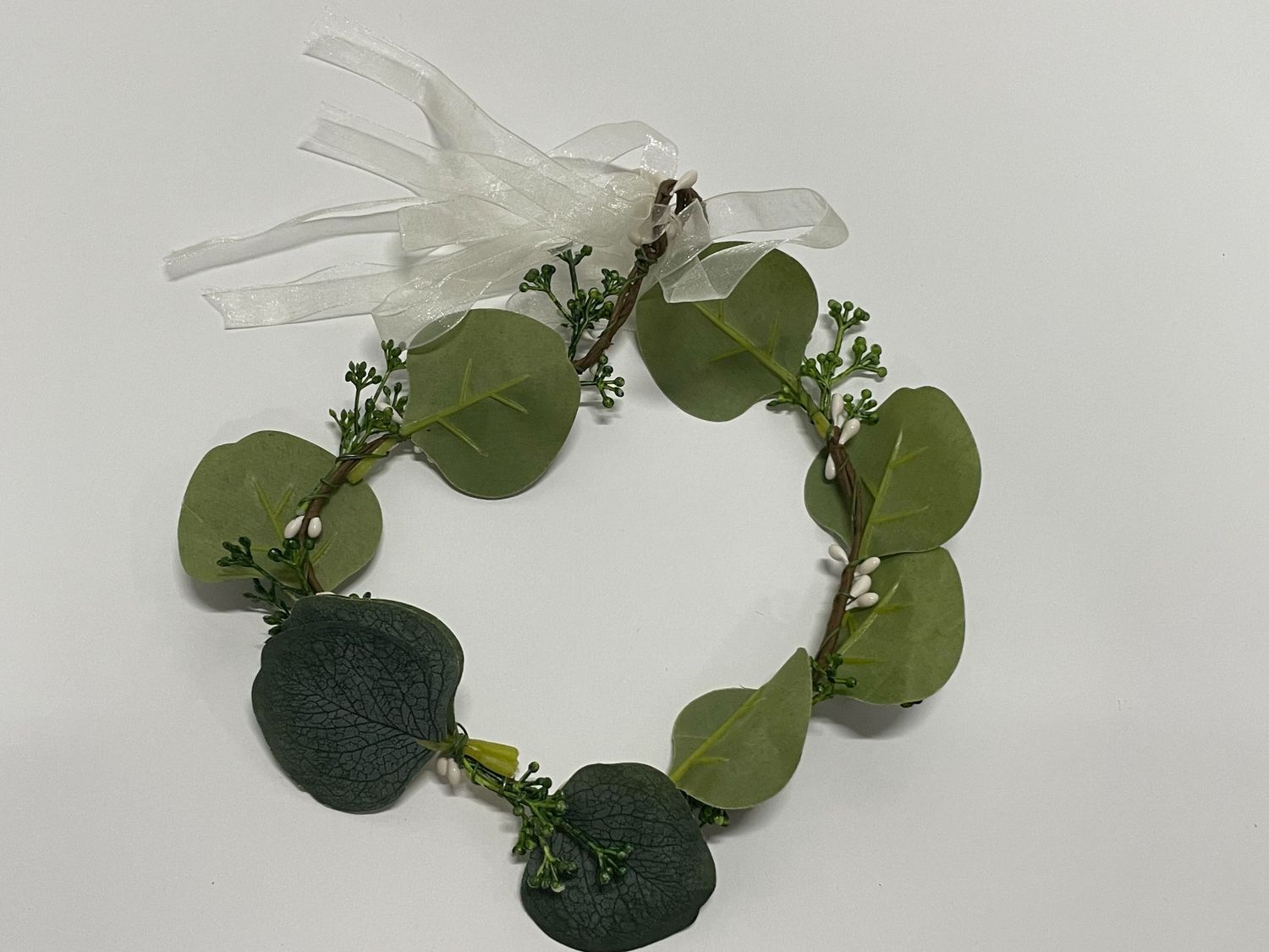 Nature-inspired headband featuring green eucalyptus leaves and white butterfly accents.