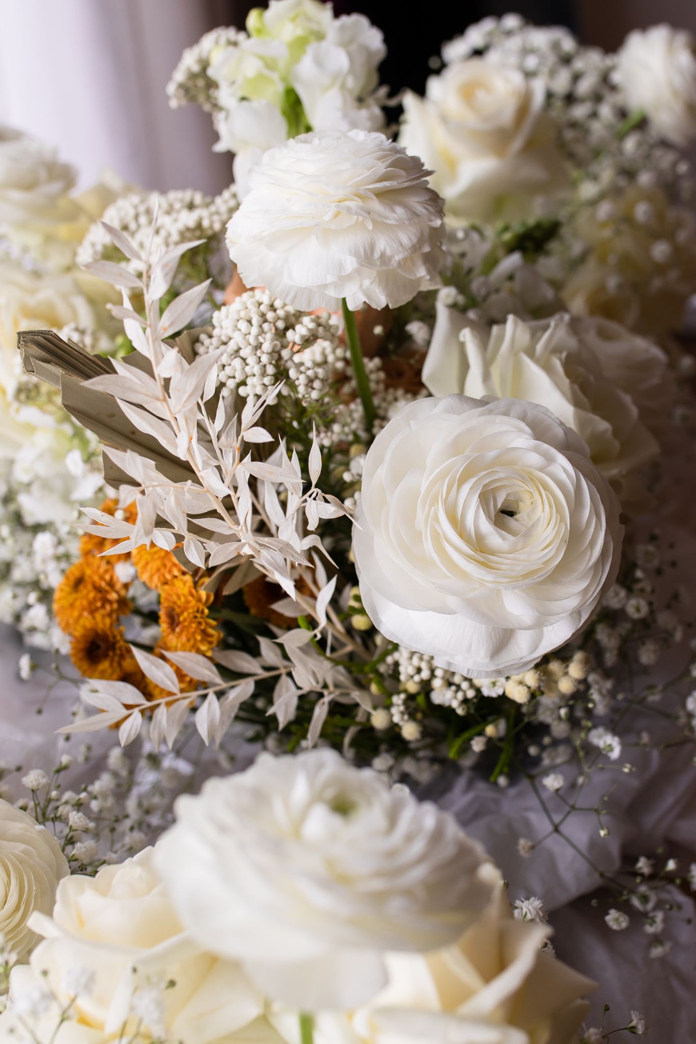 Elegant white roses and baby's breath wedding bouquet with delicate greenery accents.