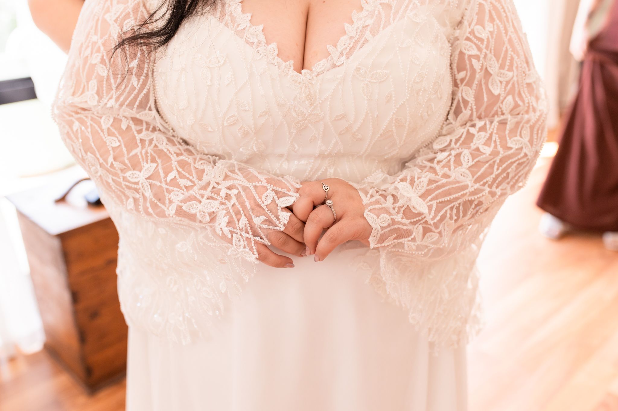Close-up detail of delicate lace sleeves on a white wedding gown.