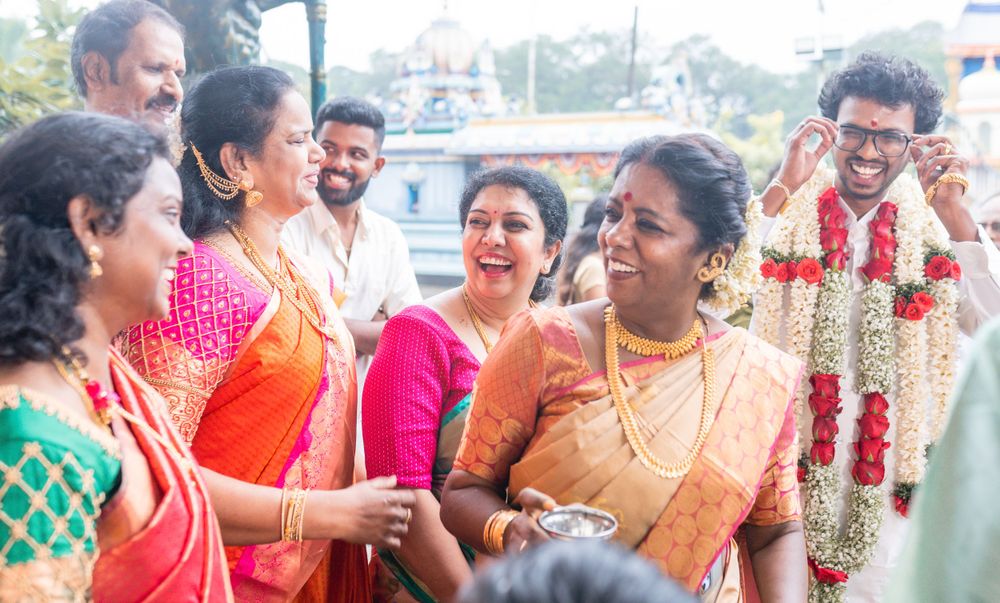 Wedding guests in vibrant saris sharing joyful moments during a traditional Indian celebration.