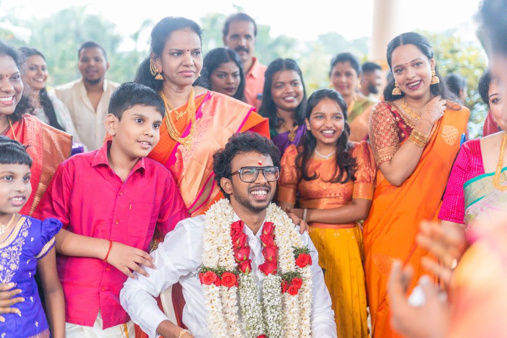 Joyous wedding celebration with guests in colorful traditional Indian attire gathered outdoors.