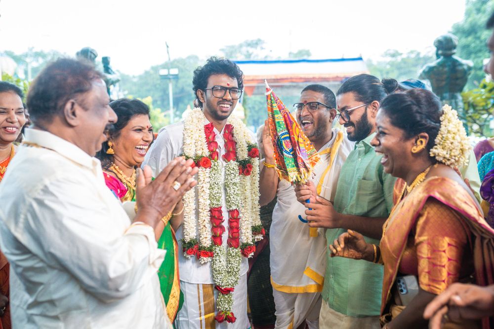 Wedding guests in traditional Indian clothing celebrating with animated expressions and gestures.
