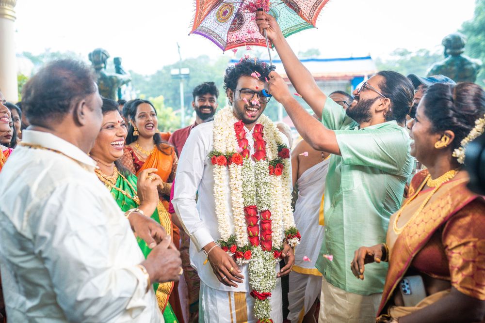 Festive Indian wedding scene with decorative umbrella and guests in traditional attire.