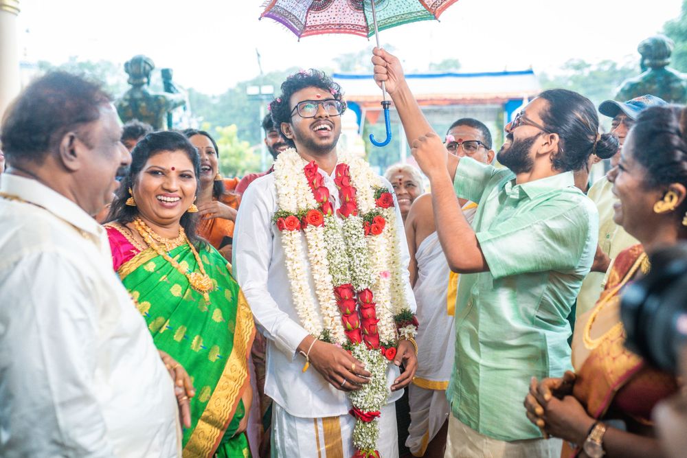 Celebratory moment at an Indian wedding with colorful umbrellas and traditional garlands.