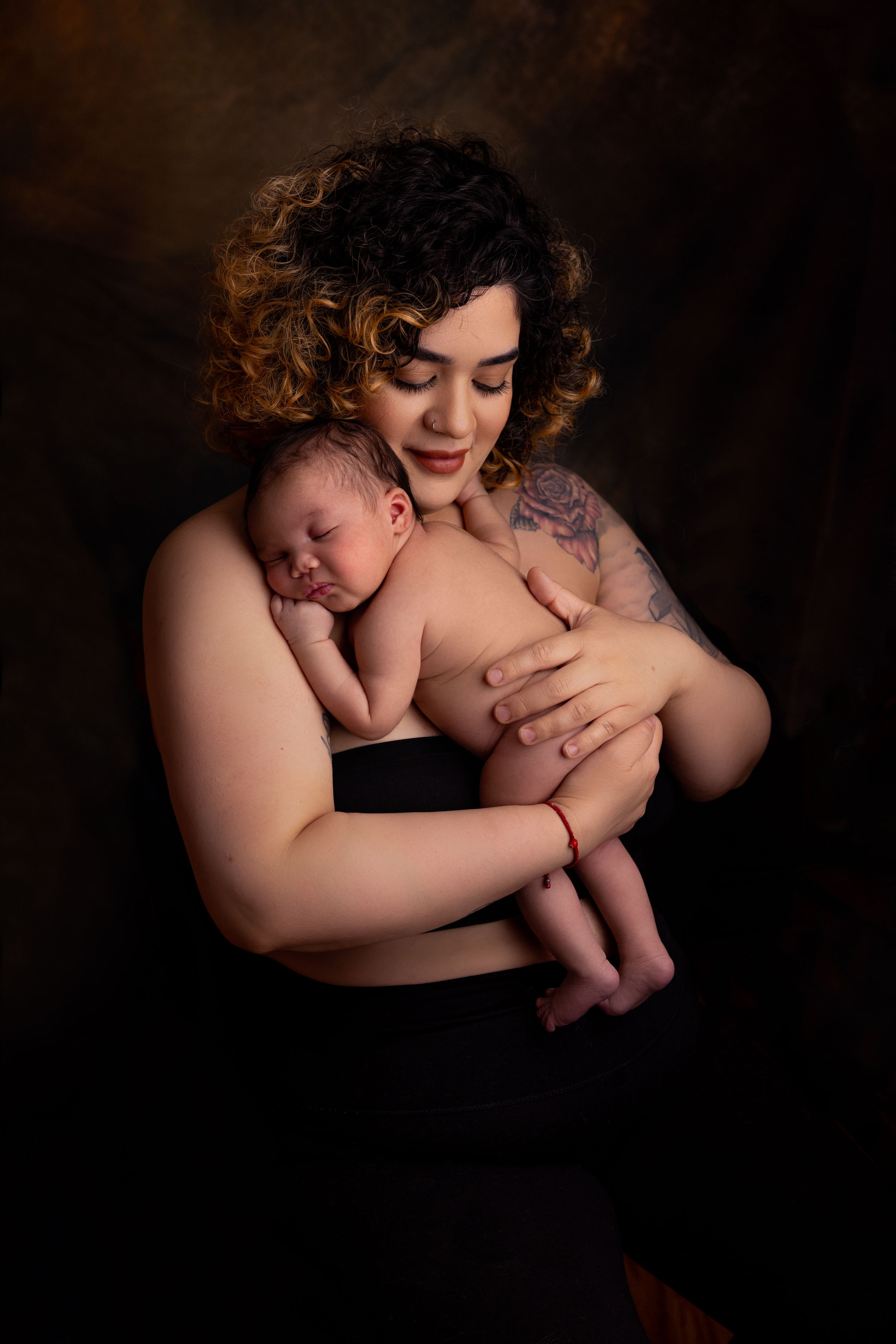 Mother holding newborn baby in studio photoshoot