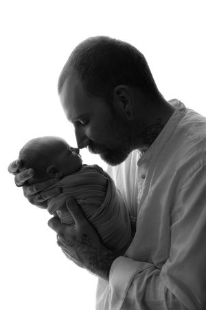 silhouette picture of parent holding newborn baby