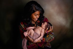 Mother holding newborn baby in arms beaverton Oregon studio photoshoot