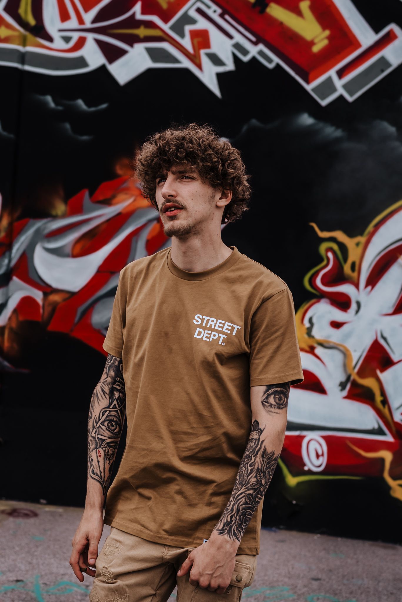 young man standing in front of graffiti