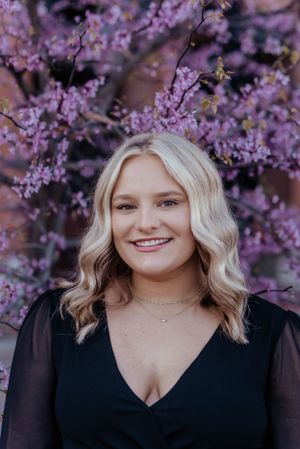 girl smiles surrounded by purple flowers