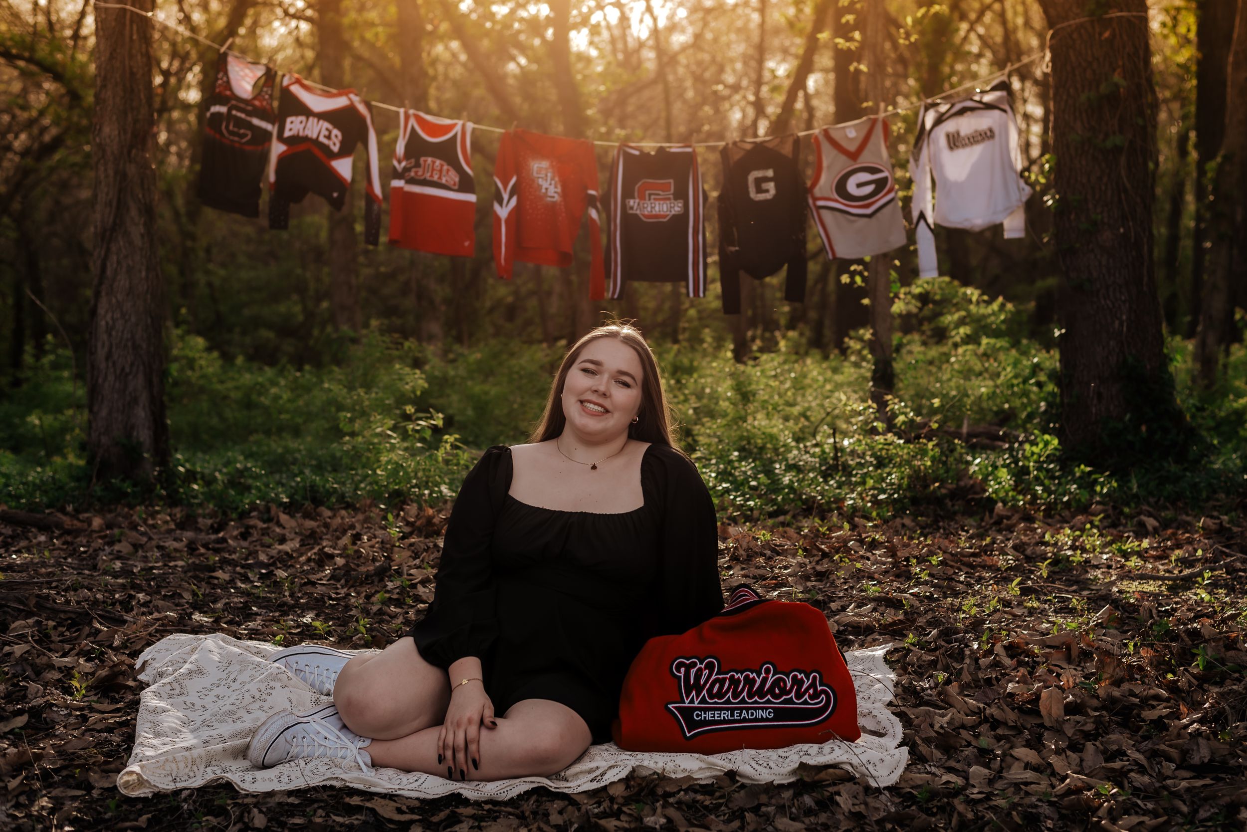 girl sits in front of dance uniforms hanging on clothes line