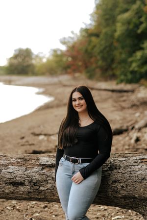 teen leaning on a limb on a beach