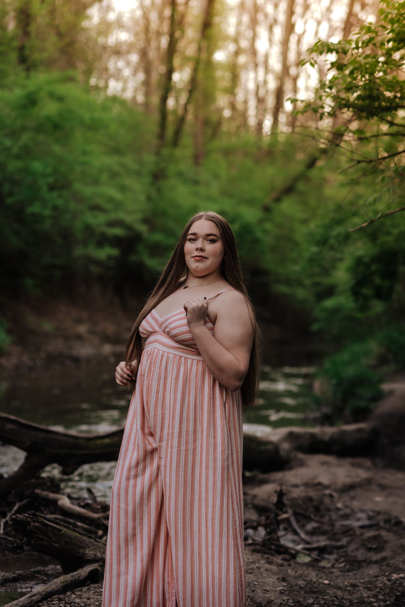 girl in striped romper standing near creek