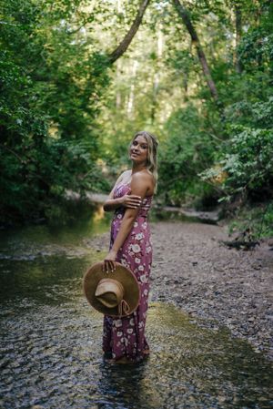 Teen girl in a floral jumper in a creek