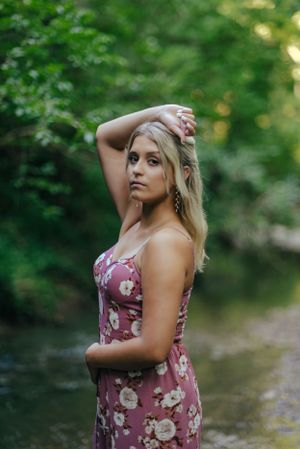 Teen girl in a floral jumper in a creek
