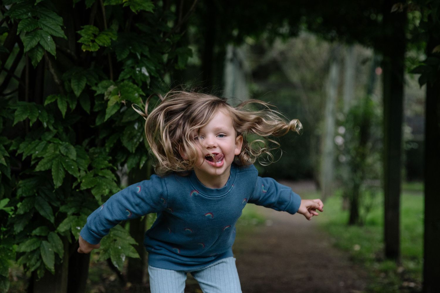 An action shot of jumping and playing outdoors with hair flying in the wind.