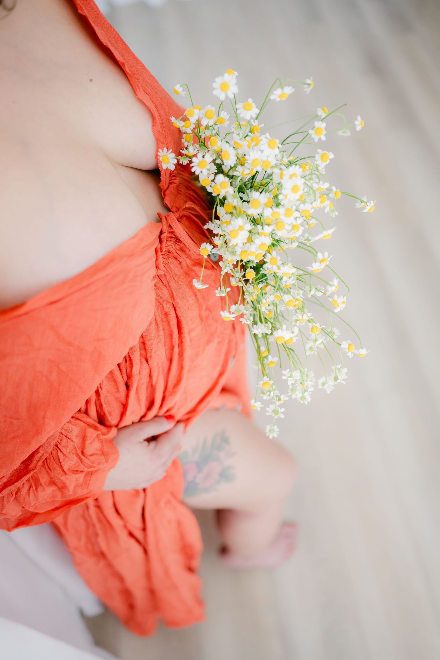 Delicate white daisies and coral fabric create a soft romantic composition.