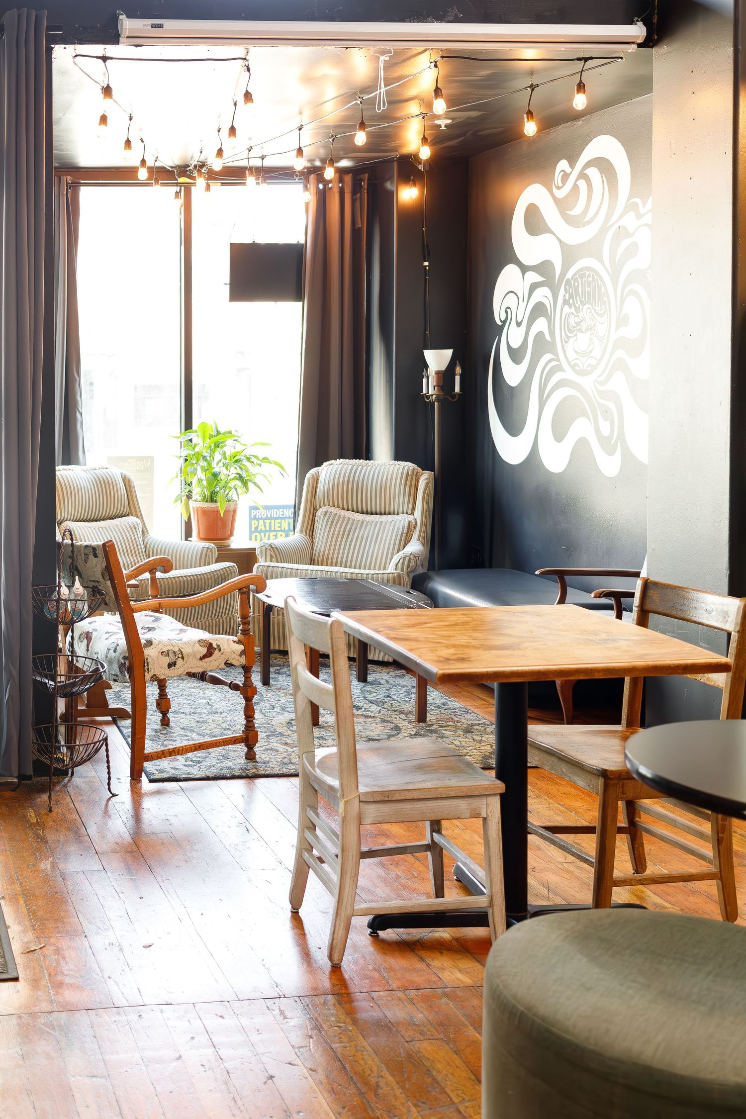 Modern coffee shop interior with wooden furniture and decorative wall art.
