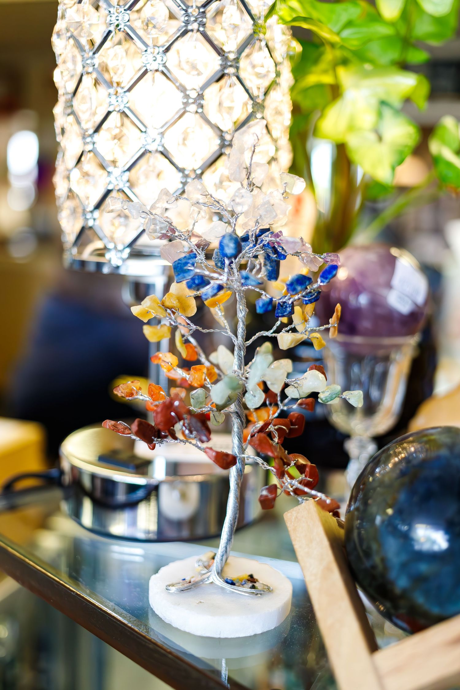 Decorative crystal lamp with colorful glass tree sculpture in retail display.