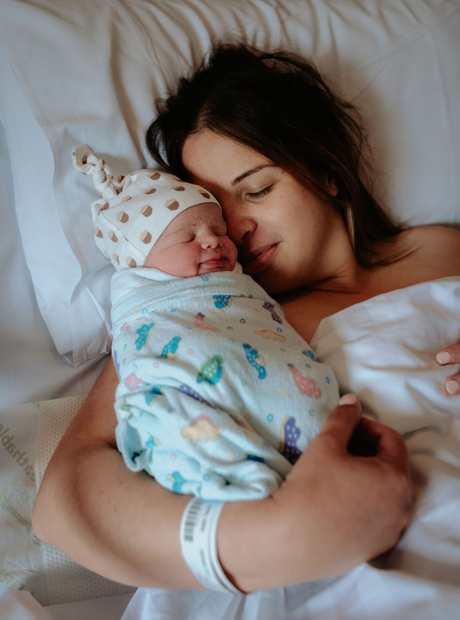 Intimate bedtime moment with sleeping baby in patterned onesie.