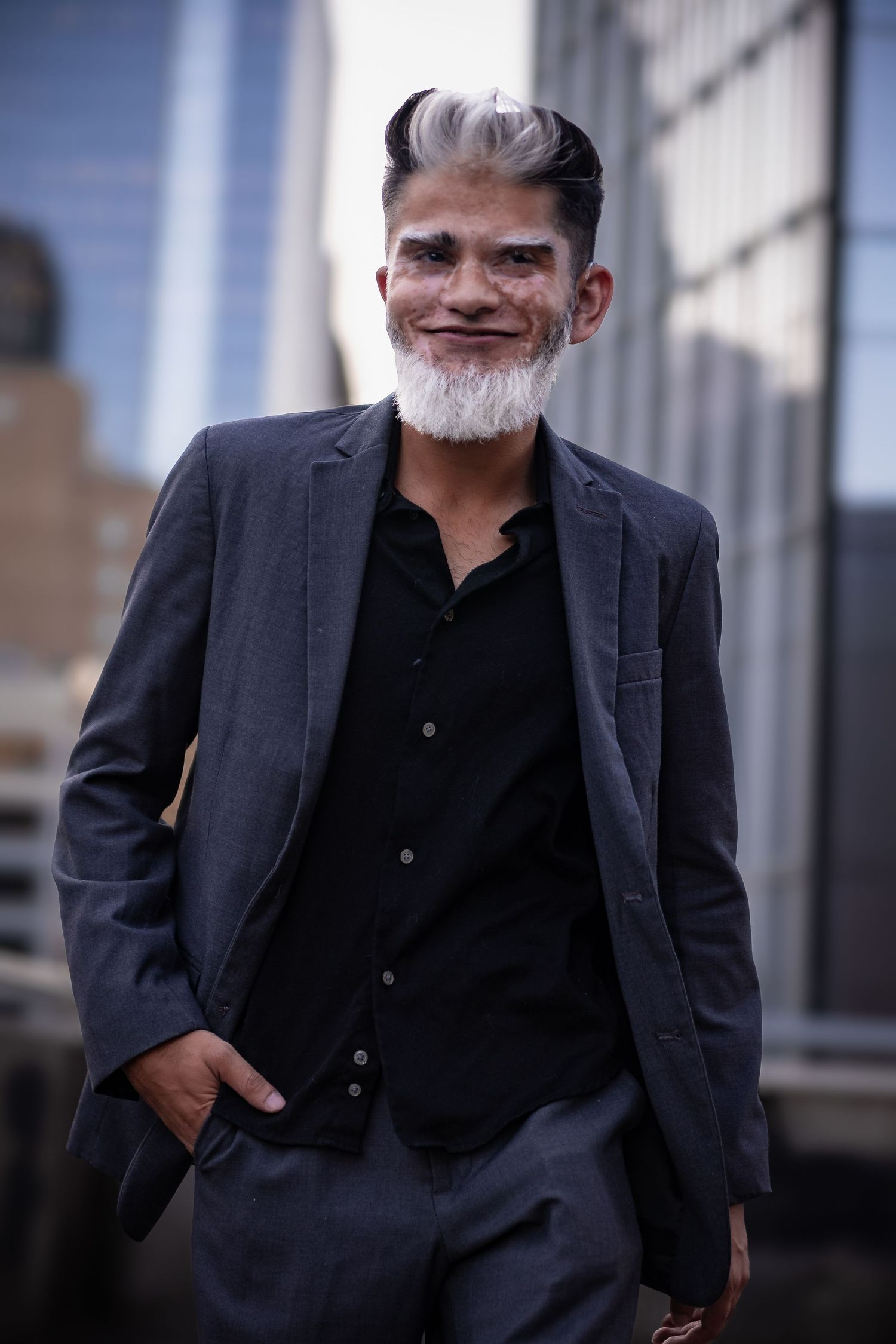 Professional portraits of a man in a dark suit against blurred city architecture.